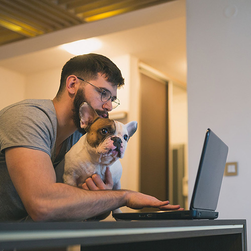 man on computer with dog